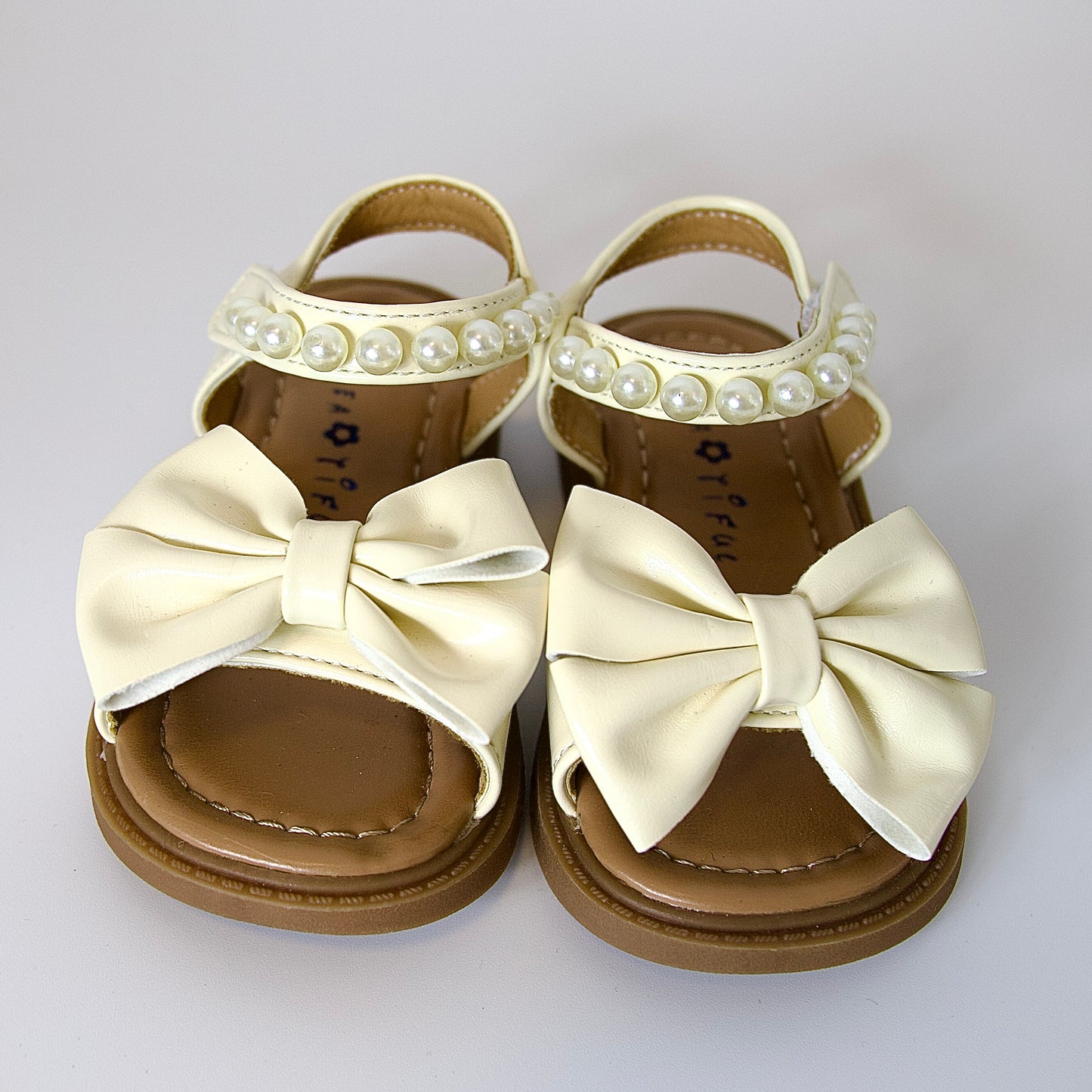 Comodidad con encanto 
Sandalias beige con moño y perlas — suaves, elegantes y perfectas para el verano