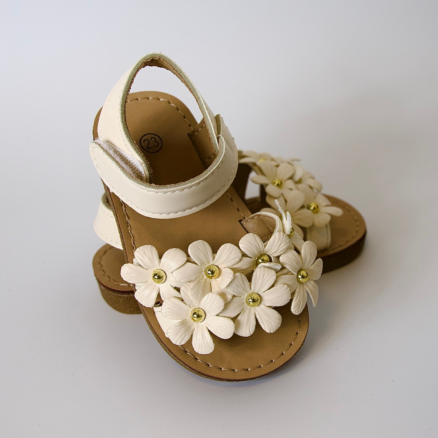 Dulzura en cada paso!
Sandalias con flores en relieve y detalles dorados