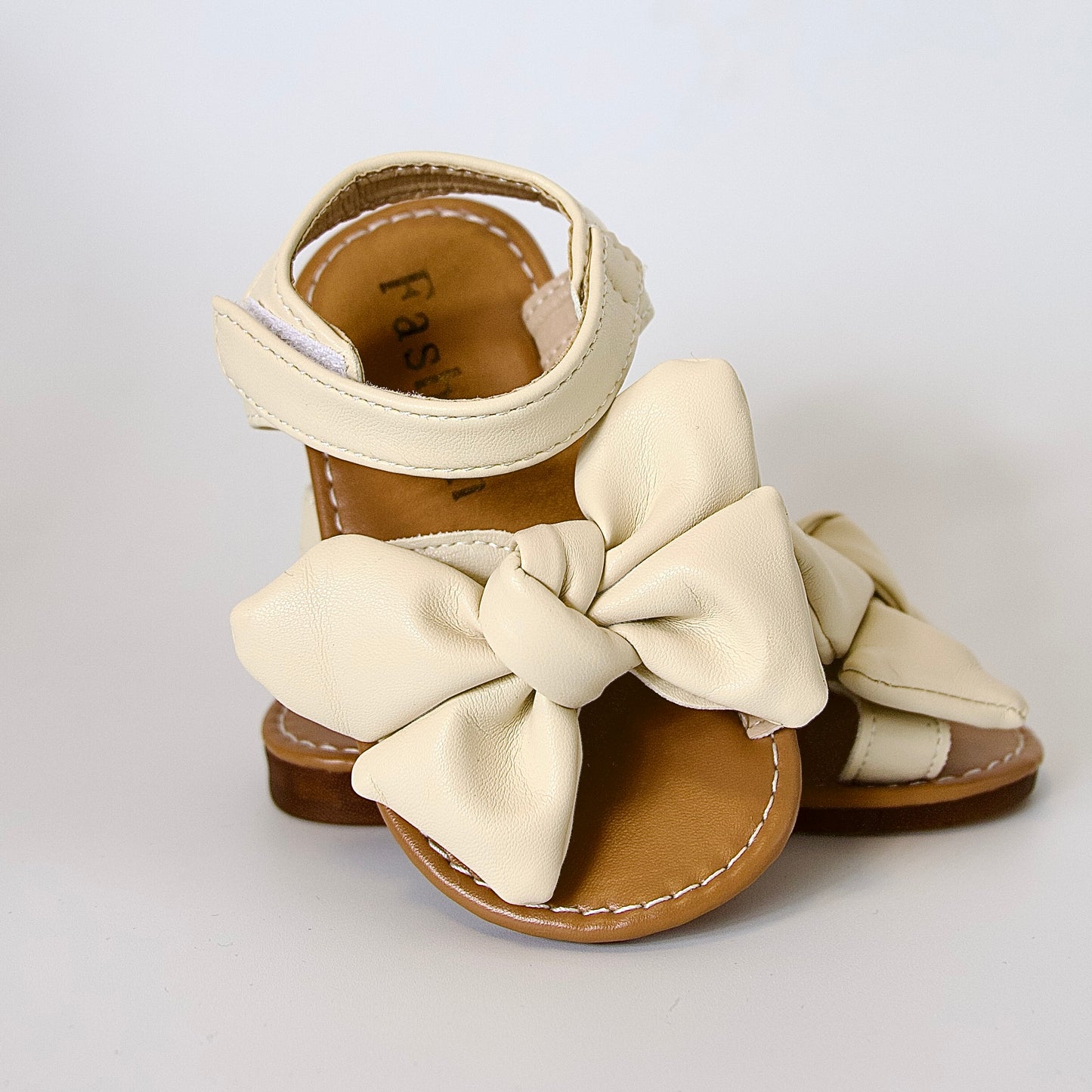 Suavidad con estilo 
Sandalias beige con moño grande — ultra cómodas y listas para jugar
