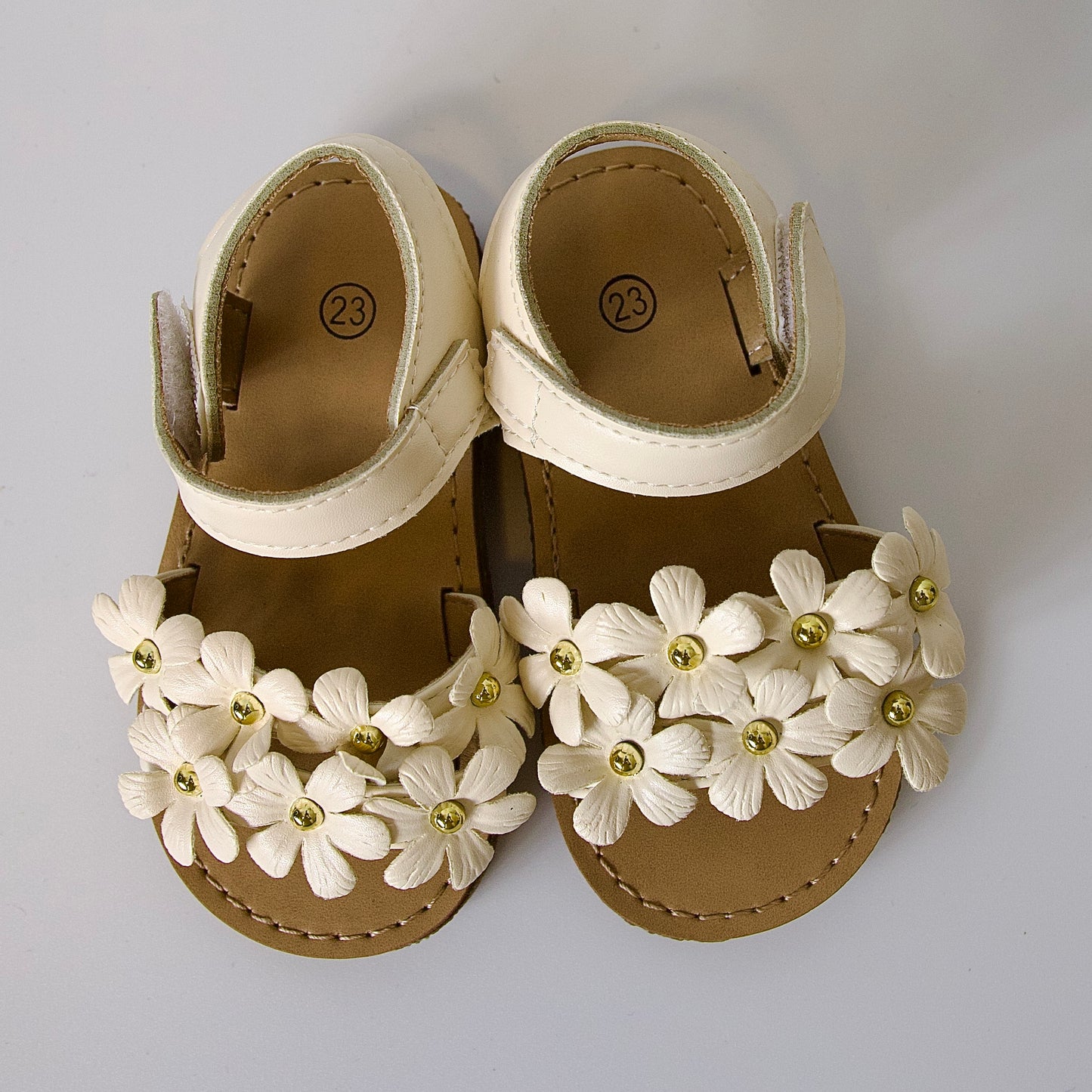 Dulzura en cada paso!
Sandalias con flores en relieve y detalles dorados