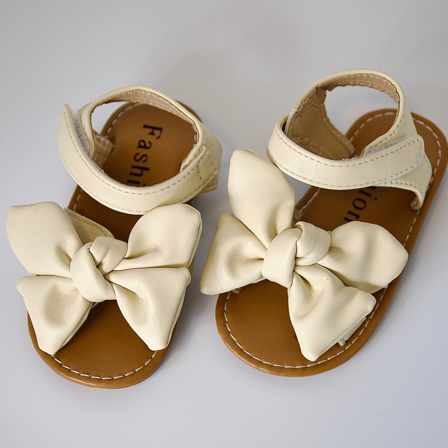 Suavidad con estilo 
Sandalias beige con moño grande — ultra cómodas y listas para jugar