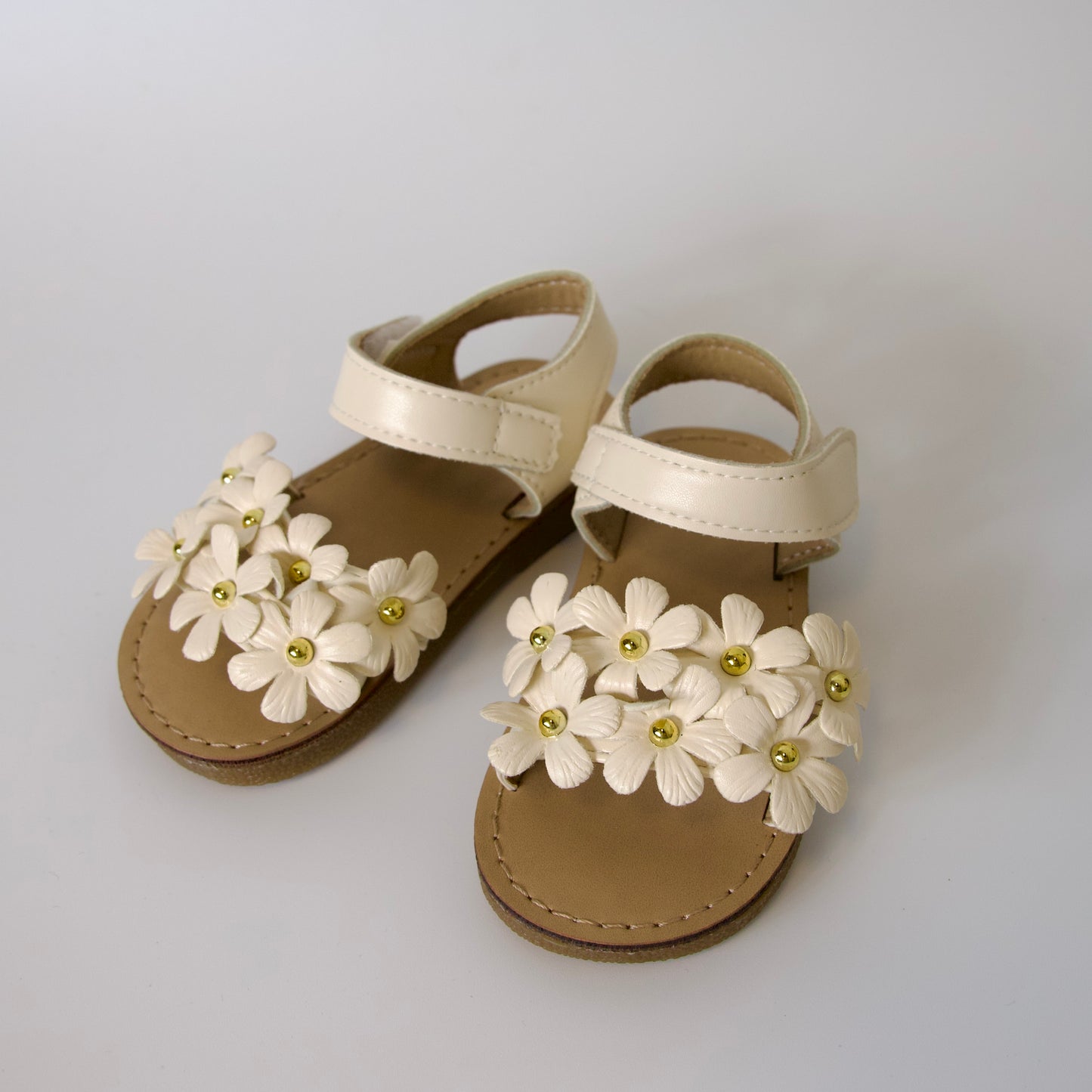 Dulzura en cada paso!
Sandalias con flores en relieve y detalles dorados