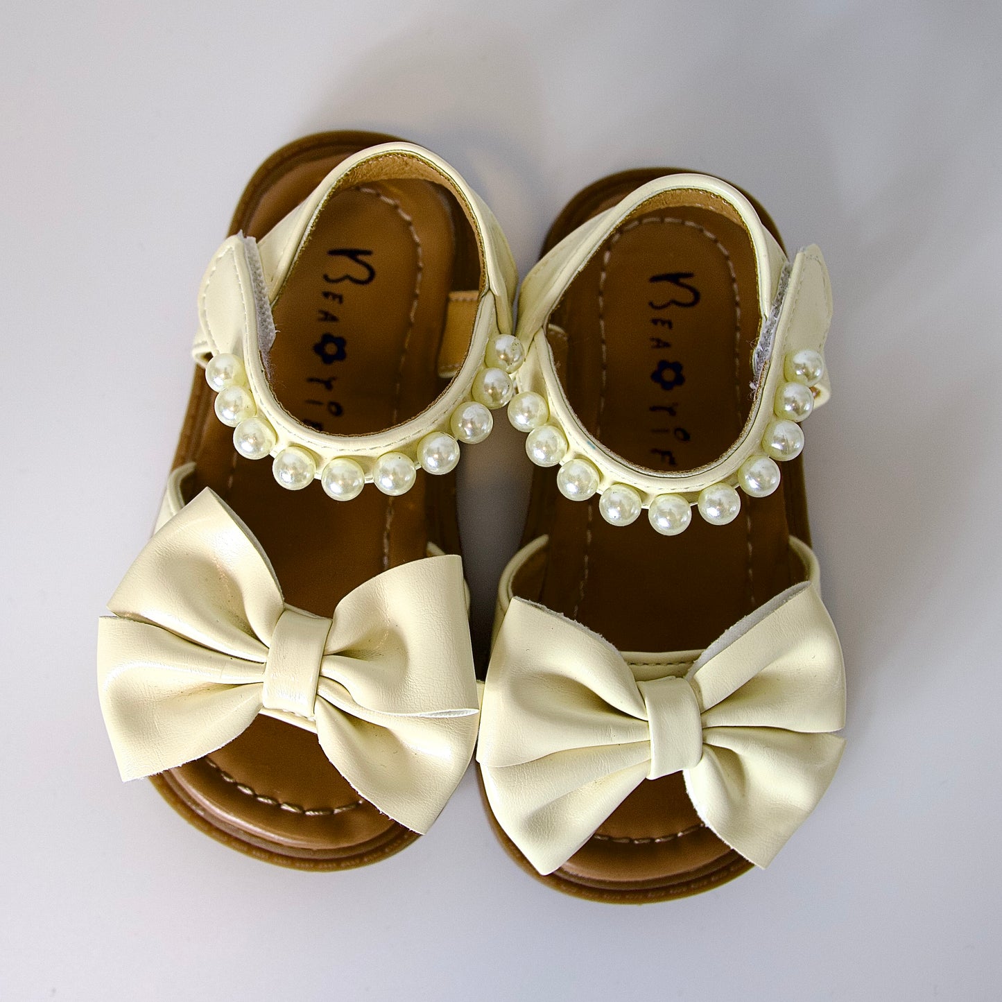 Comodidad con encanto 
Sandalias beige con moño y perlas — suaves, elegantes y perfectas para el verano